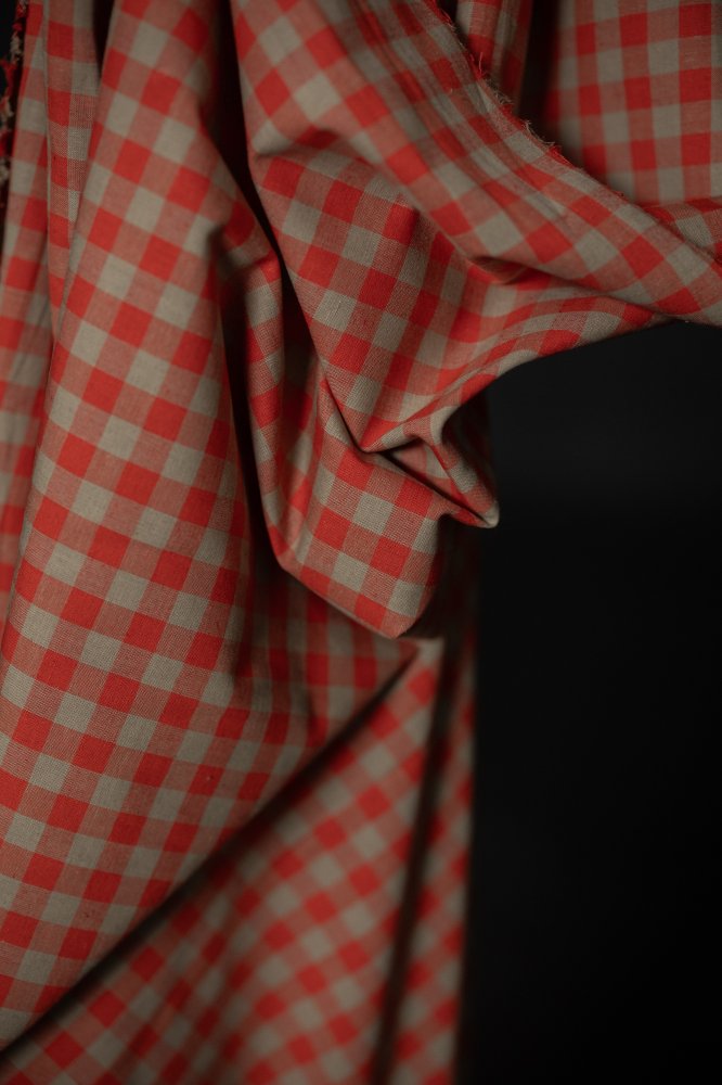 Close-up of Betsy Organic Cotton Linen Gingham fabric pattern showcasing the vibrant coral orange and light brown checks, featured by Merchant & Mills.